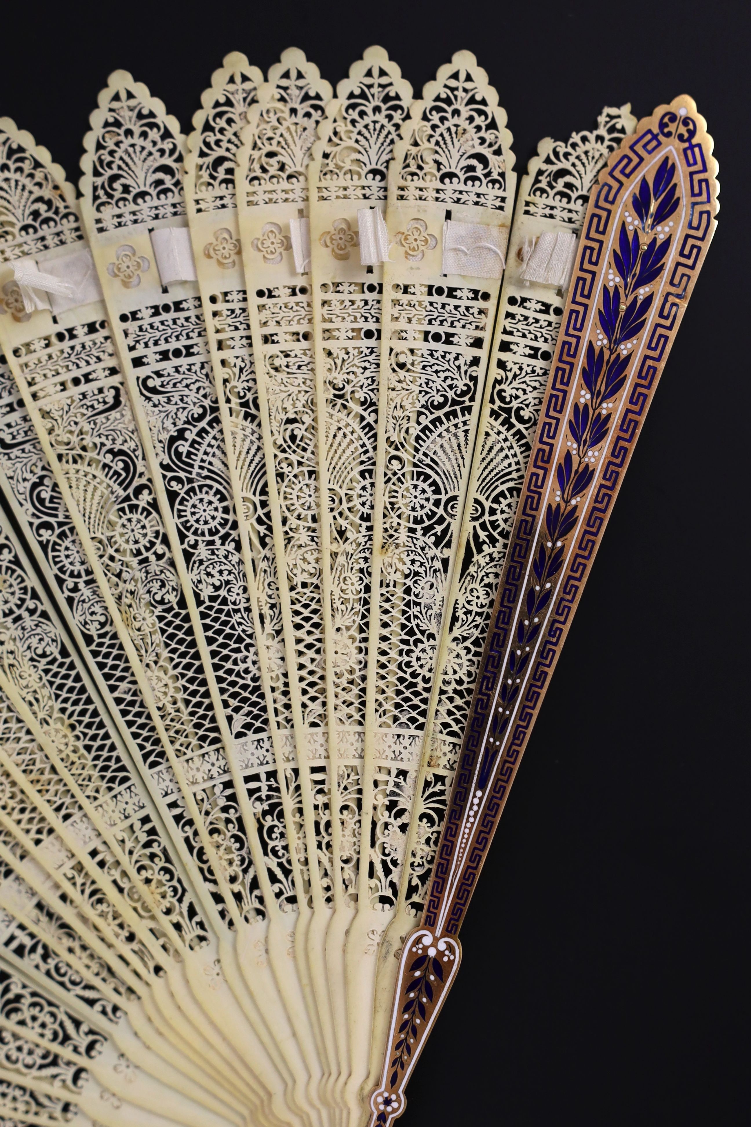 A German or Swiss gold, enamel and ivory brise fan, 19th century, possibly made for the Ottoman market, 17.3 cm closed, slight losses to sticks, needs rethreading